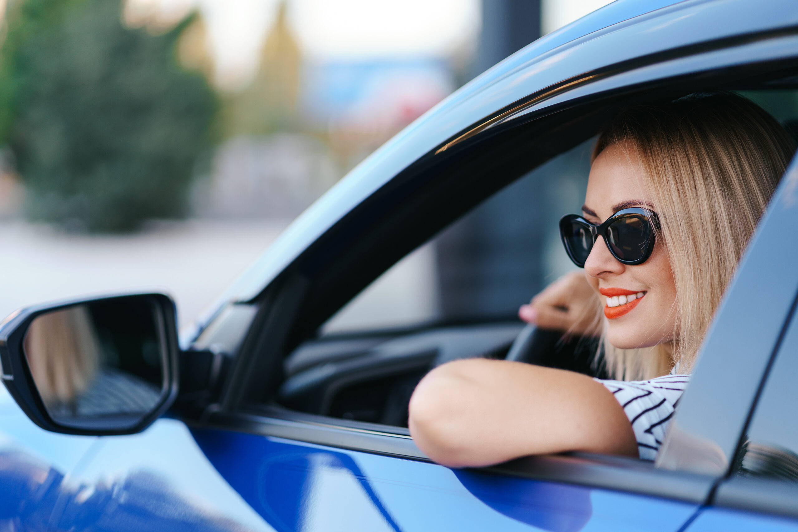Woman in sunglasses driving a car